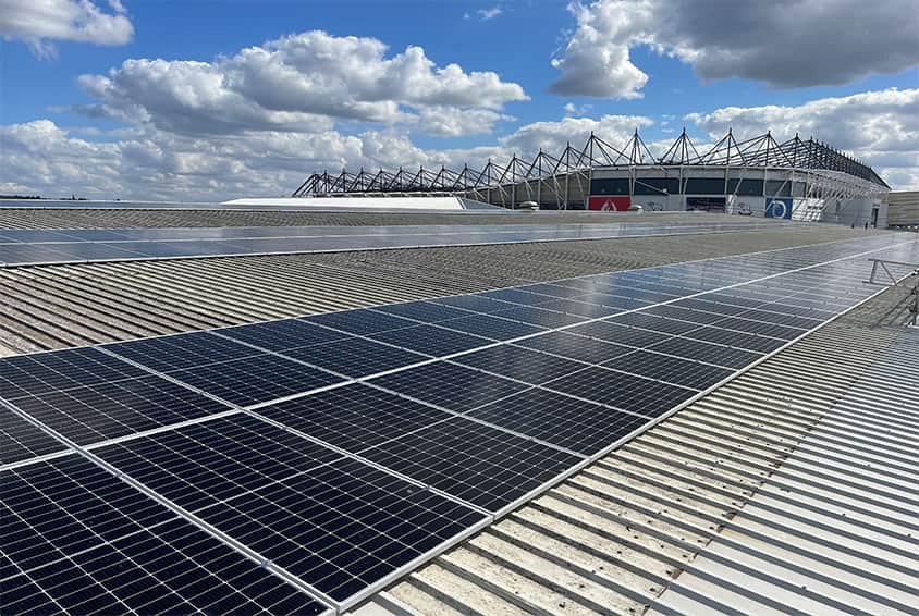 A solar panel, located high atop the Frenger Systems UK Office; with the Derby Rams Stadium in the background